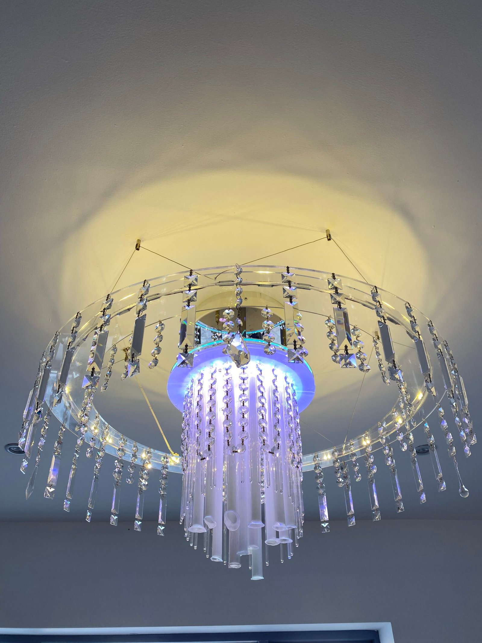 Grand multi-tiered luxury Italian crystal chandelier hanging in a premium modern design hotel foyer with elegant architectural detailing
