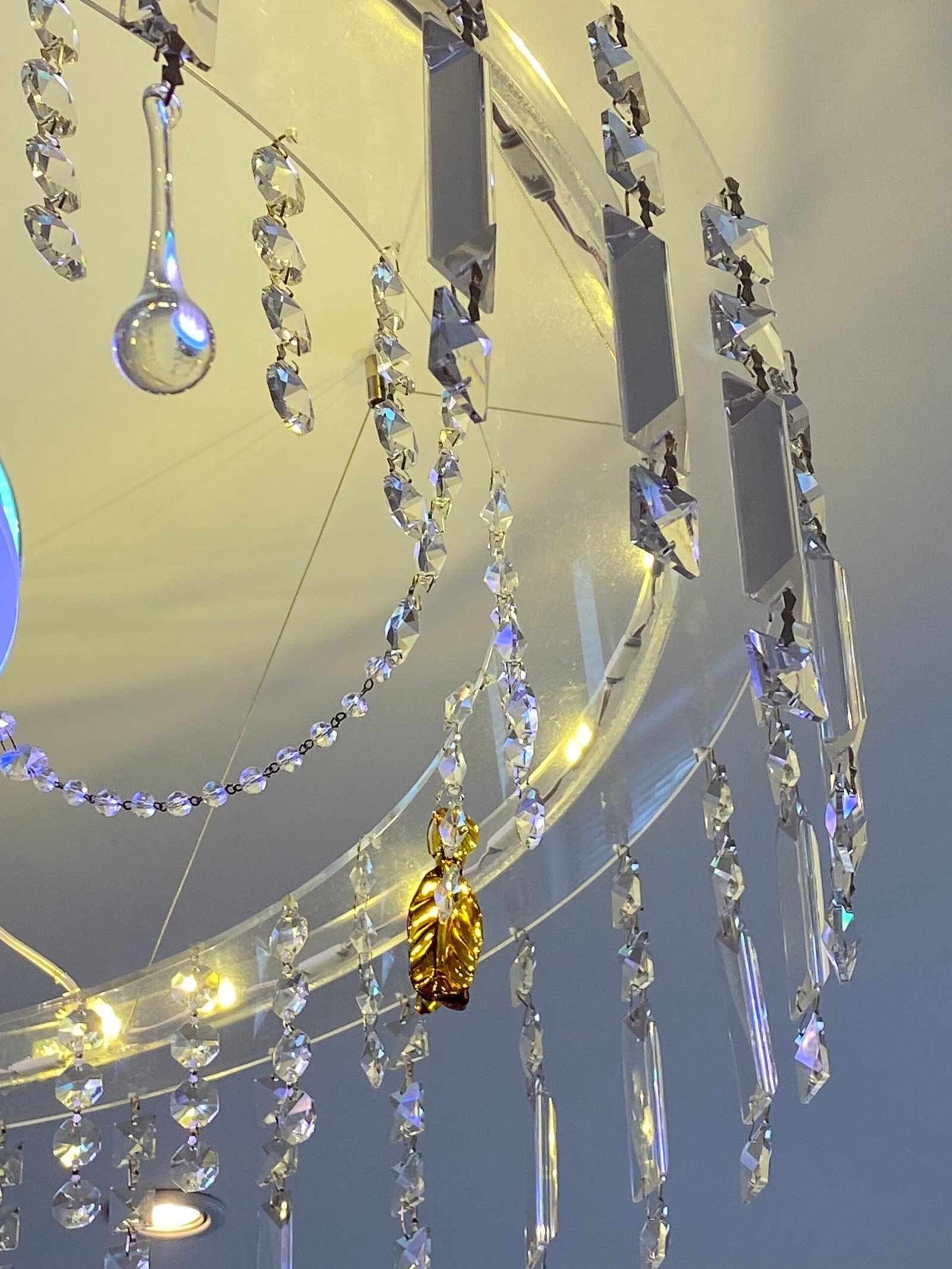 Close-up of a modern leaf-shaped pendant light crafted from authentic Murano crystal glass with a warm, integrated LED glow. Bespoke crystal murano chandeliers